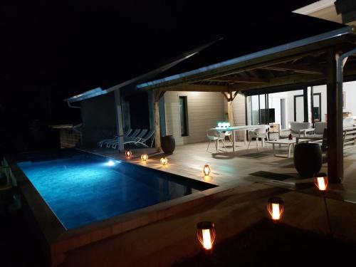 a swimming pool in a backyard at night at LE PETIT PARADIS in Sainte-Rose