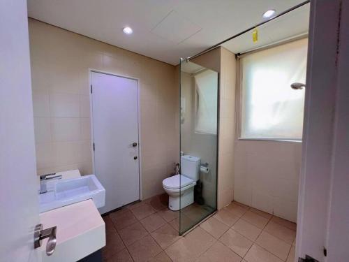 a bathroom with a toilet and a sink and a mirror at Comfy Staycation 4PX with Free Parking, Direct Linked SOGO & Central I-CITY in Shah Alam