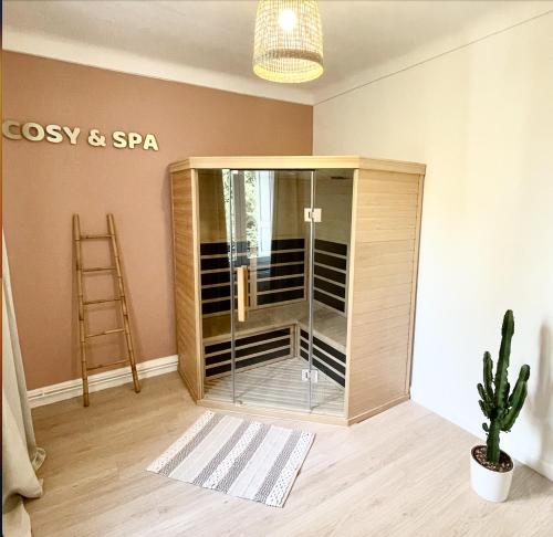 Cette chambre dispose d'une douche avec une porte en verre. dans l'établissement Le Golf Sauna - Cosy & SPA - 2 chambres - 4 pers, à Saint-Étienne