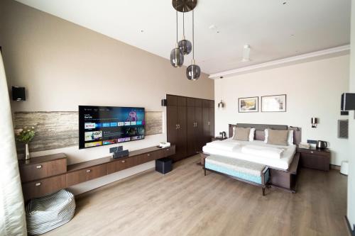 a bedroom with a bed and a flat screen tv at Central Bed & Breakfast in Kolkata