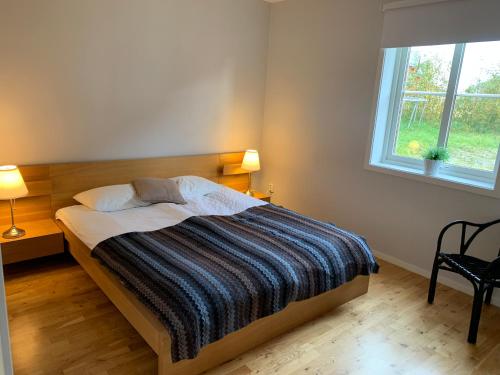 een slaapkamer met een bed met een gestreepte deken en een raam bij Funäsdalsporten Röda Husen Funäsdalen in Funäsdalen