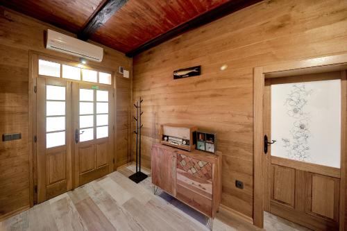um quarto com paredes de madeira, 2 portas e uma janela em Kuća za odmor IVAN em Velika Gorica