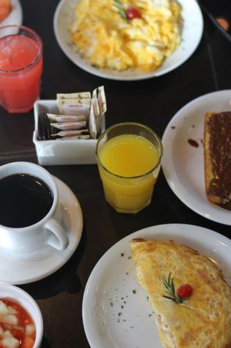 a table with plates of breakfast food and a cup of coffee at Jade Hotel Brasília in Brasilia