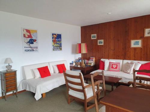 a living room with two white couches and a table at Sunny 2 BR w large terrace, stunning views & pool in Crans-Montana