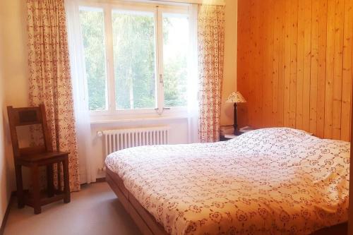 a bedroom with a bed and a window at Sunny 2 BR w large terrace, stunning views & pool in Crans-Montana