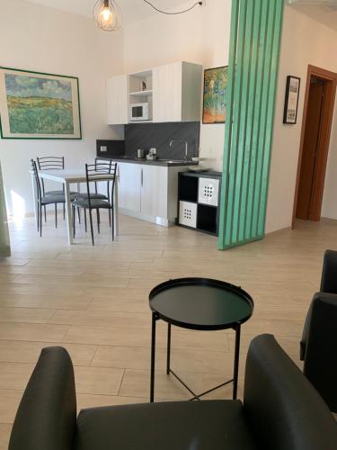 un soggiorno e una cucina con tavolo e sedie di I Monolocali Del Boccaccio a Milano Marittima
