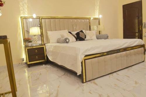 a bedroom with a large bed with a gold frame at Charming Home banglow in Karachi