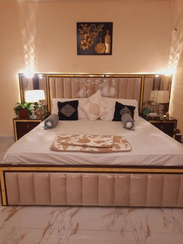Charming Home banglow في كراتشي: غرفة نوم بسرير كبير عليها شراشف ووسائد بيضاء