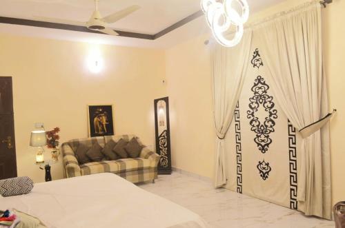 a living room with a bed and a couch at Charming Home banglow in Karachi