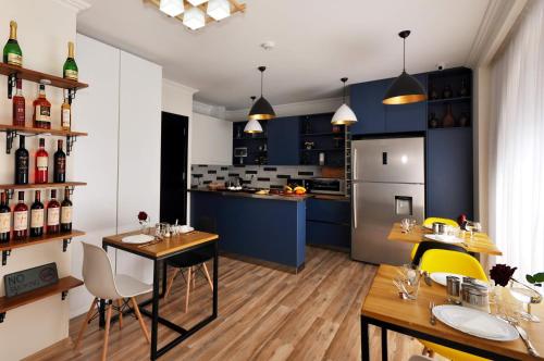 Hotel Art Nikola Rooms في تبليسي: مطبخ مع دواليب زرقاء وطاولة وكراسي