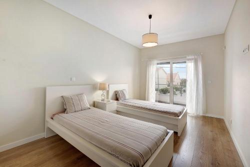 a bedroom with two beds and a window at Sunset Holiday Home in Fernao Ferro