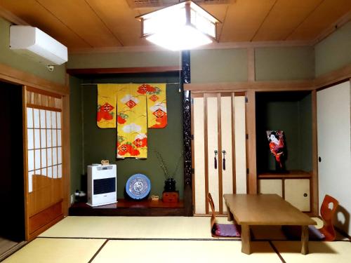 a room with a table and a door with a television at Plum House Otaru in Otaru