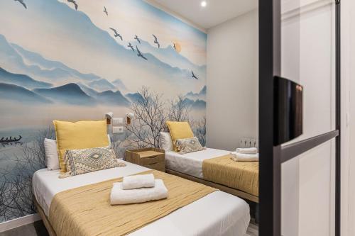 2 camas en una habitación con un mural en la pared en BNBHolder Fresh Confort II en Madrid
