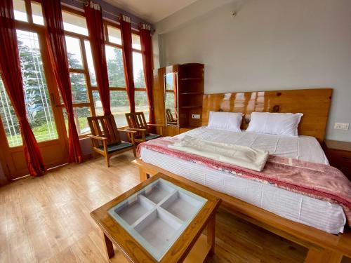- une chambre avec un lit et une table avec un miroir dans l'établissement Hotel Mansarovar Inn, à Munsyari