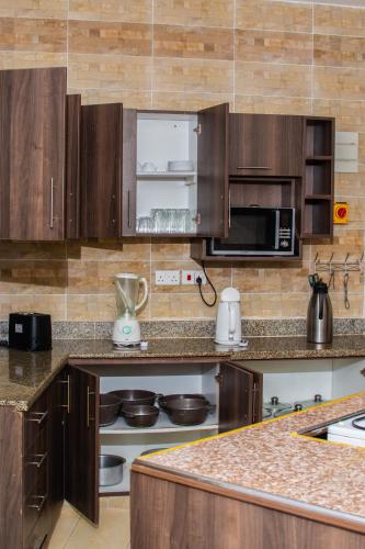 a kitchen with wooden cabinets and a counter top at ZaNaKri Homes ;A Great Panorama of Indian Ocean in Mombasa
