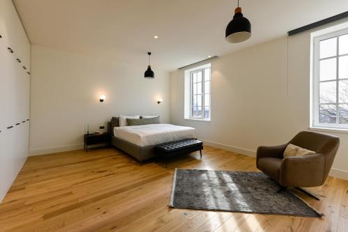 sypialnia z łóżkiem i krzesłem w obiekcie 12A, Luxe & Uniek - Bioscoopzaal - Terras - Uitzicht w mieście Oisterwijk