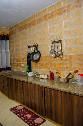 a kitchen counter with pots and pans on the wall at ZaNaKri Homes ;A Great Panorama of Indian Ocean in Mombasa