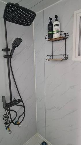 a shower in a bathroom with a shower head at Sunset Lounge Guesthouse in Springwood