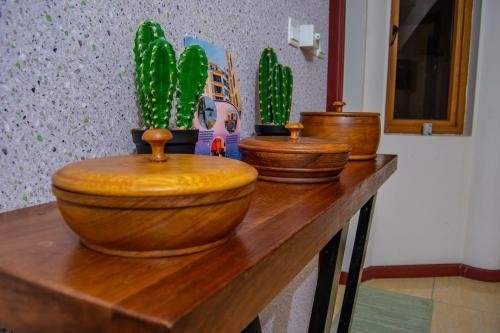 three wooden toilets sitting on a wooden table with cactuses at ZaNaKri Homes ;A Great Panorama of Indian Ocean in Mombasa