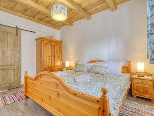 a bedroom with a wooden bed and two night stands at Nyírfa-Lak Apartman in Szilvásvárad