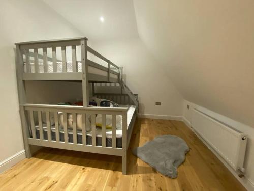 Habitación con escalera y alfombra en el suelo de madera. en Holiday Home, Sleep 10 in London, en South Norwood