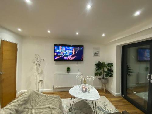 a living room with a tv on the wall at Holiday Home, Sleep 10 in London in South Norwood