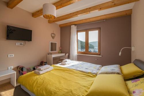 ein Schlafzimmer mit einem gelben Bett und einem Fenster in der Unterkunft Villa Porto in Krnica