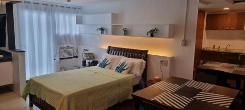 a small bedroom with a bed and a table at Condo studio type in Manila