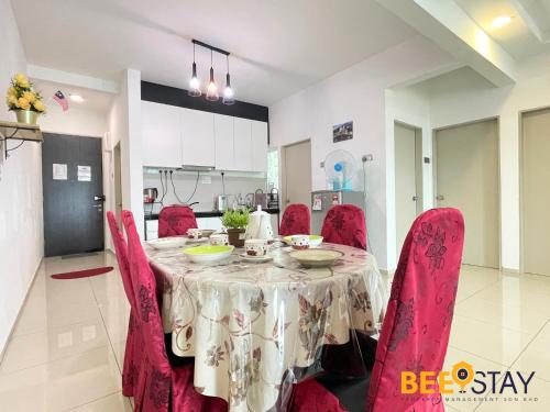 a dining room table with red chairs and a table cloth at KLIA Ehsan Residences Sepang Nilai in Sepang