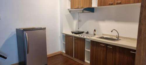 a small kitchen with a sink and a refrigerator at Condo studio type in Manila