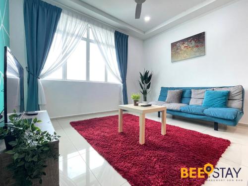 a living room with a blue couch and a red rug at KLIA Ehsan Residences Sepang Nilai in Sepang