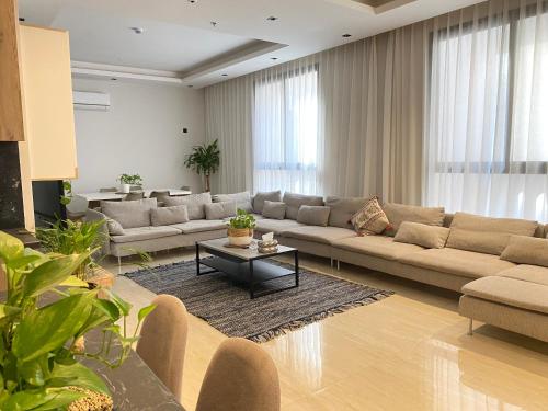 una gran sala de estar con sofás y una mesa. en الرياض البوليفارد شقق عبيه Vip الفاخره, en Riad
