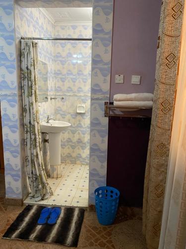 a bathroom with a shower with a sink and a toilet at Penuel Plaza Hotel in Kimana