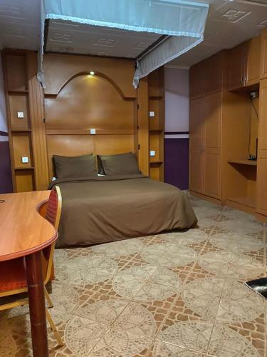 una camera con letto con testiera in legno e tavolo di Penuel Plaza Hotel a Kimana