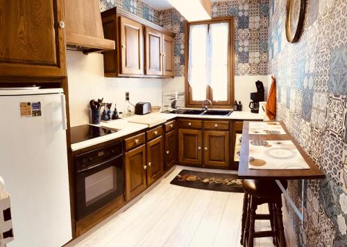 a small kitchen with wooden cabinets and a sink at Gîte de la Cigale in Burzet