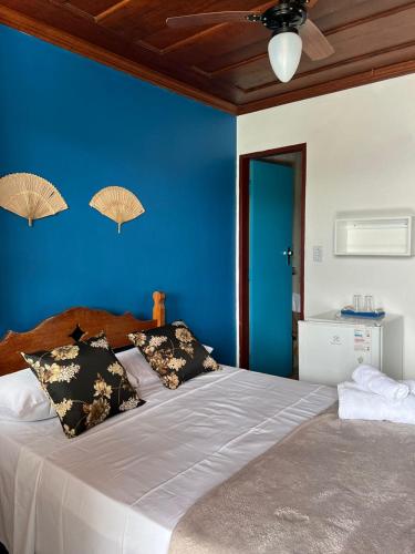 a bedroom with a large bed with a blue wall at Pousada Marques in Paraty
