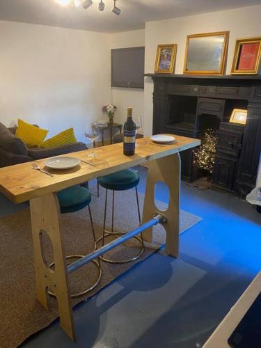 een woonkamer met een houten tafel met stoelen en een open haard bij Turners Albert Road Basement Apartment in Colne