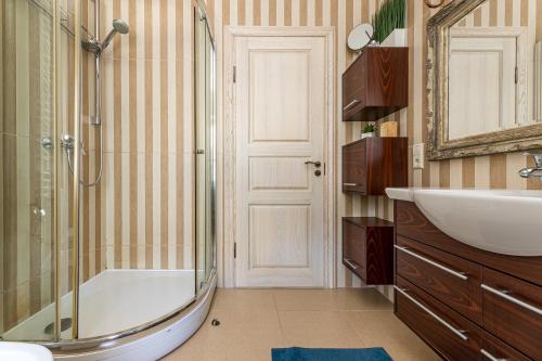 een badkamer met een bad, een wastafel en een douche bij Villa with private pool Laumes juosta in Palanga
