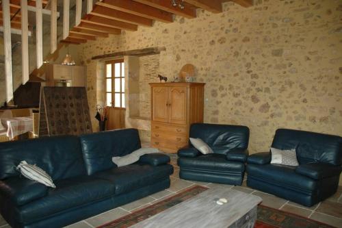 - un salon avec des canapés en cuir bleu et une table dans l'établissement Belle grange du 18ème restaurée avec charme, à Rouffignac-Saint-Cernin-de-Reilhac