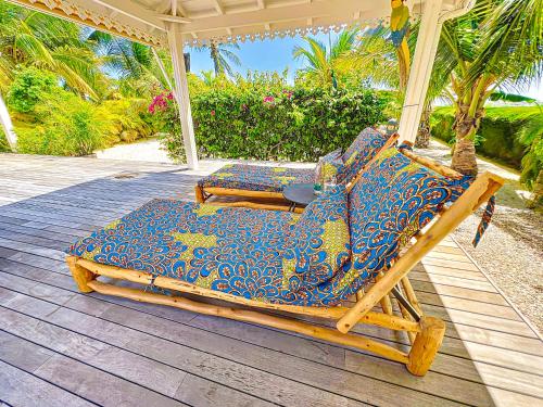 a couple of chairs sitting on a porch at Villa Marie, swimming pool, beach, pontoon and jacuzzi, all private in Baie Nettle