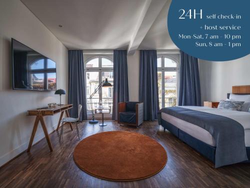 Schlafzimmer mit einem Bett, einem Schreibtisch und Fenstern in der Unterkunft Classik Hotel Antonius in Köln