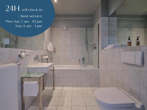 La salle de bains est pourvue d'une baignoire, de toilettes et d'un lavabo. dans l'établissement Classik Hotel Antonius, à Cologne