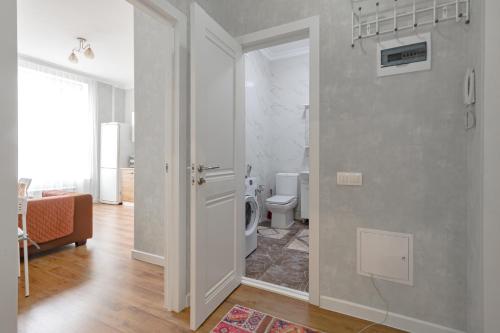 an open door to a bathroom with a toilet at Апартаменты в ЖК Apple City in Astana