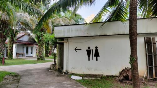 a sign on the side of a building with two toilets at Twin Palms Resort in Sihanoukville