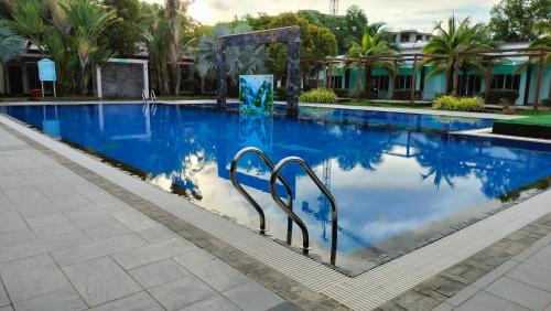 a swimming pool with blue water and palm trees at Twin Palms Resort in Sihanoukville
