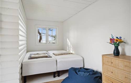 Habitación blanca con cama y jarrón de flores en Beach Front Home In Martofte With Kitchen, en Martofte