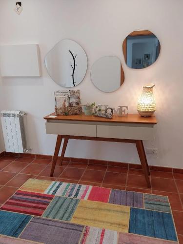 a table with two mirrors and a tv on a wall at Casa com Alma by LovelyStay in Fátima
