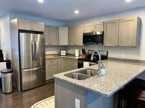 a kitchen with a stainless steel refrigerator and a sink at New luxury spacious 3BR 3BA 1 mile from Mt Snow in Dover