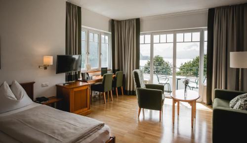 ザンクト・ギルゲンにあるSeehotel Billrothのベッド、テーブル、椅子が備わるホテルルームです。