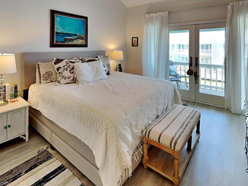 a bedroom with a large bed and a balcony at Canal Royale in Rockport